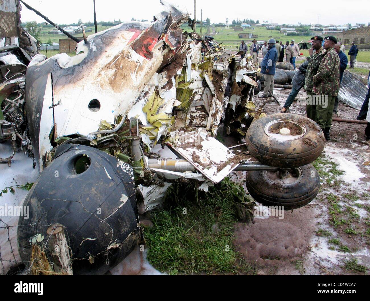 Policemen and emergency workers look at the wreckage of a twin-engine Buffalo plane that crashed in Ruai, the outskirts of Kenya's capital Nairobi, December 30, 2006. A Kenyan plane carrying relief supplies and fuel to neighbouring war-torn Somalia crashed and burst into flames on Saturday, but officials said there were no fatalities. REUTERS/Thomas Mukoya (KENYA) Stock Photo