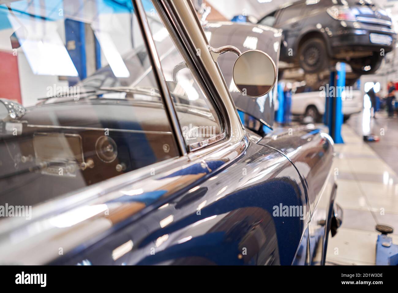 Garage with retro cars. Mechanic in classic car restoration