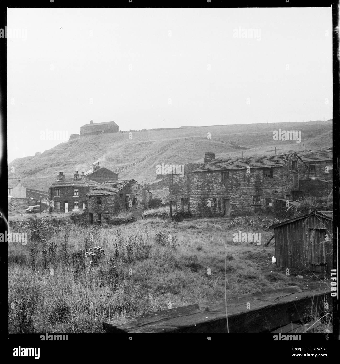 A view looking north west from land off Market Street, Shawforth showing a cluster of houses located on Old Lane and Cowm Street, with the house known as Cowm, visible on the hill above, Whitworth, Rossendale, Lancashire, UK. Stock Photo