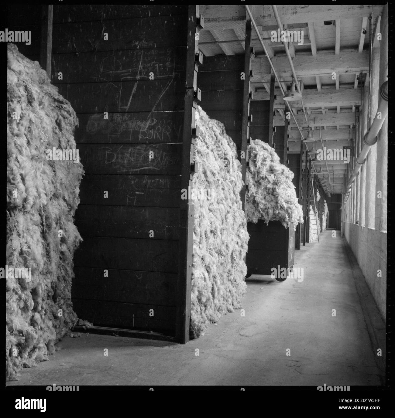 A bay stacked with raw wool awaiting processing in Salt's Mill, Victoria Road, Saltaire, Shipley, Bradford, West Yorkshire, UK. Stock Photo