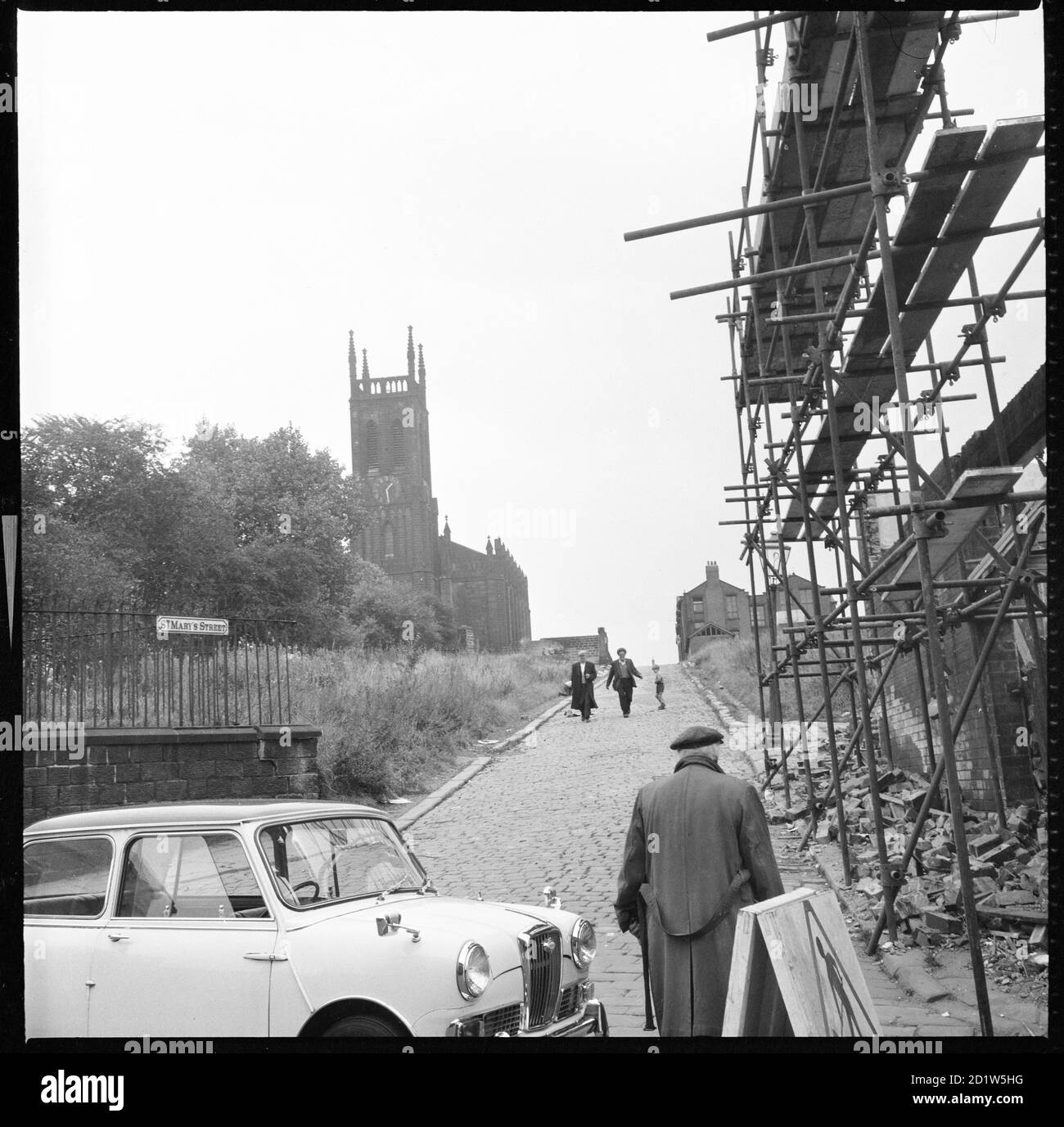 A view looking along St Mary's Street towards St Mary's Church with scaffolding around partially demolished buildings in the foreground, Quarry Hill, Leeds, UK. Stock Photo