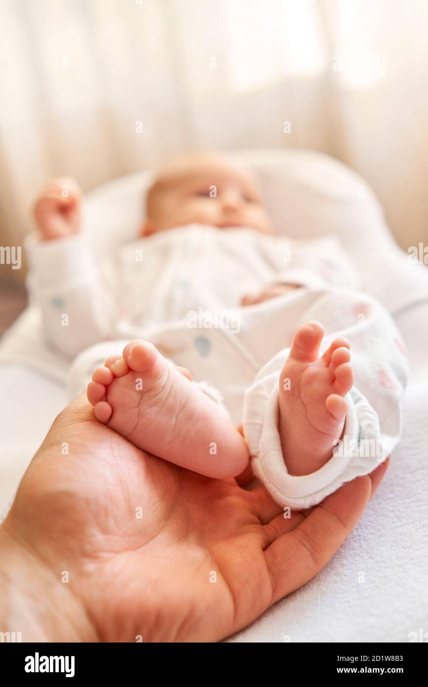 Feet of newborn baby. Baby little feet in parents hand. Feet skin care