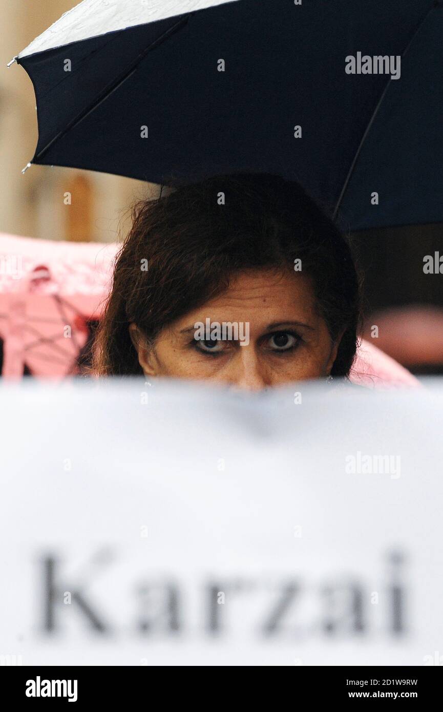 Souad Sbai, a lawmaker from the People of Freedom party, is seen behind a banner during a demonstration for Sayed Perwiz Kambakhsh, an Afghan journalist who was arrested in 2007 after downloading material from the internet relating to the role of women in Islamic societies and given the death sentence for blasphemy, in Rome April 1, 2009. Souad Sbai spent years in Italy defending battered women in the Moroccan immigrant community before the death threats started coming. Now that she's a member of parliament, she wonders if they'll ever stop.      REUTERS/Alessandro Bianchi    (ITALY POLITICS C Stock Photo