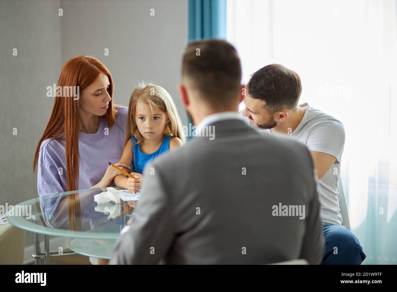 rear view on psychologist listening to family problems, they sit at