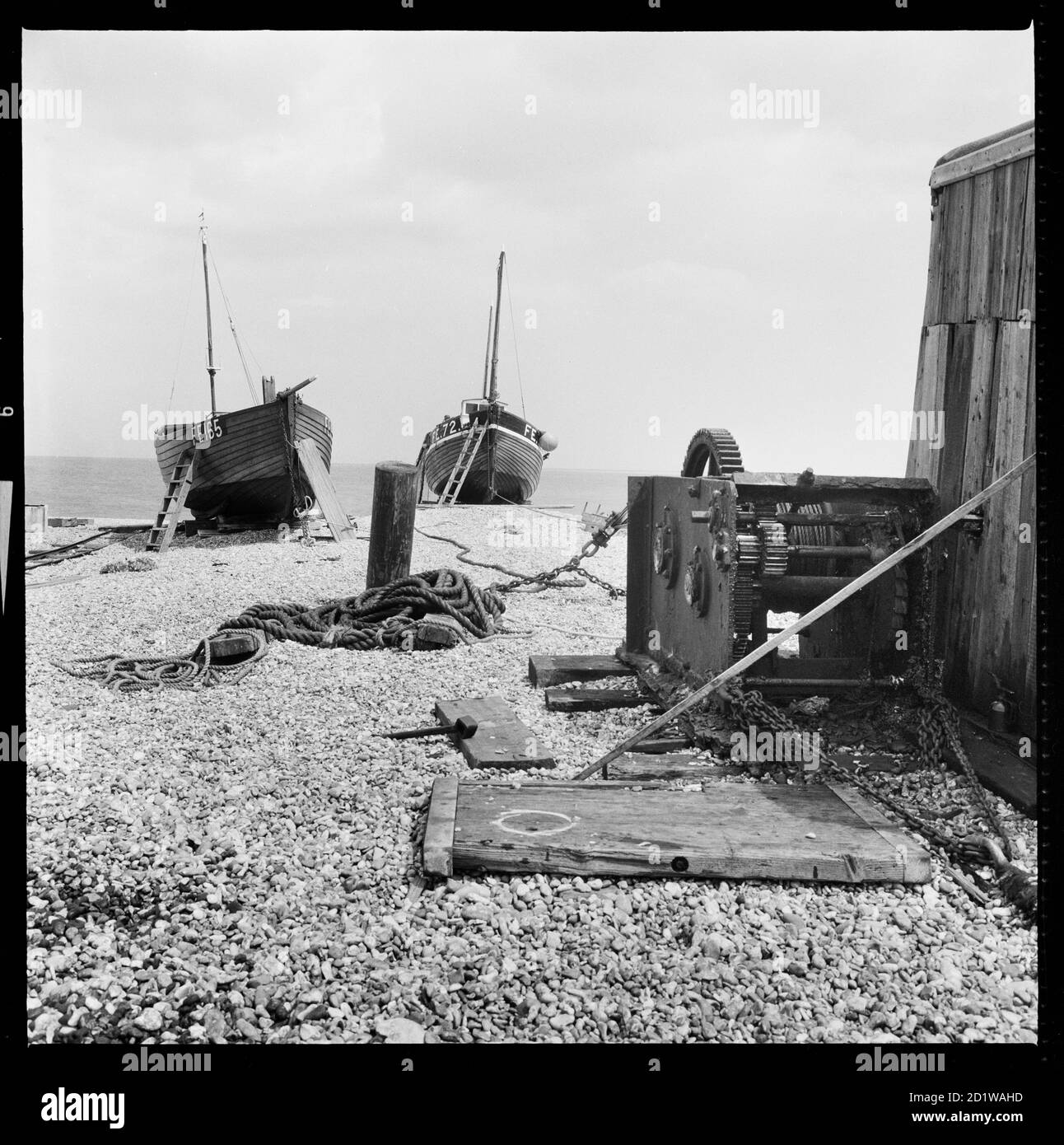 Dungeness, Lydd, Shepway, Kent. A boat winch and nearby boats on the beach at Dungeness. Stock Photo