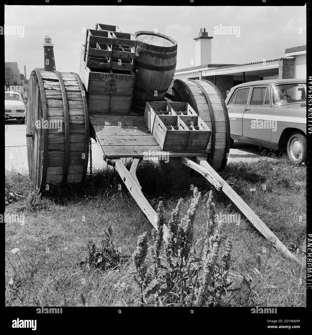 Dungeness, Lydd, Shepway, Kent. A horse-drawn cart loaded with beer crates and a barrel on display in the car park beside Dungeness Old Lighthouse    The cart was used to deliver beer the public houses of Dungeness before the building of a road across the beach. Stock Photo