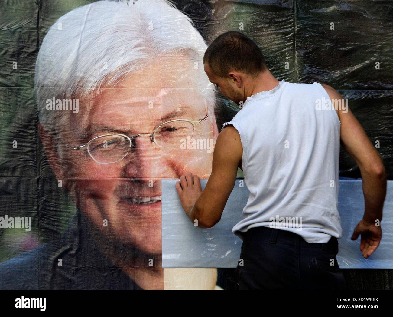 Workers paste up election posters showing German Foreign Minister and candidate for chancellor of Germany's Social Democratic Party (SPD) Frank-Walter Steinmeier in Berlin, August 31, 2009. Senior members of Chancellor Angela Merkel's conservatives warned on Monday that heavy losses in weekend regional votes were a wake up call one month before the German election and called for a more aggressive campaign. REUTERS/Tobias Schwarz (GERMANY POLITICS ELECTIONS IMAGES OF THE DAY) Stock Photo
