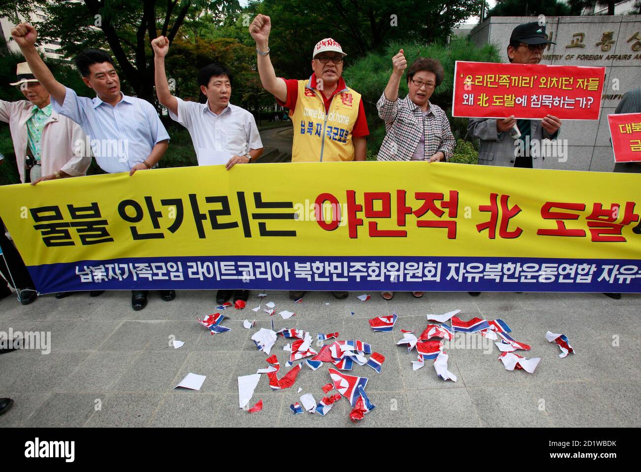 Anti-North Korea protesters shout slogans after tearing North Korean flags during a rally denouncing North Korea's sudden release of water from their dams on the Imjin River, in front of the Integrated Government Complex in Seoul September 8, 2009. South Korea demanded an apology from North Korea on Tuesday for its sudden release of water into the river flowing across their border, causing a pre-dawn flash flood on Sunday that swept away six people, casting a pall over recently warming ties between the rivals. The banner reads: 'Respond strongly against the extreme barbarous provocation by Nor Stock Photo