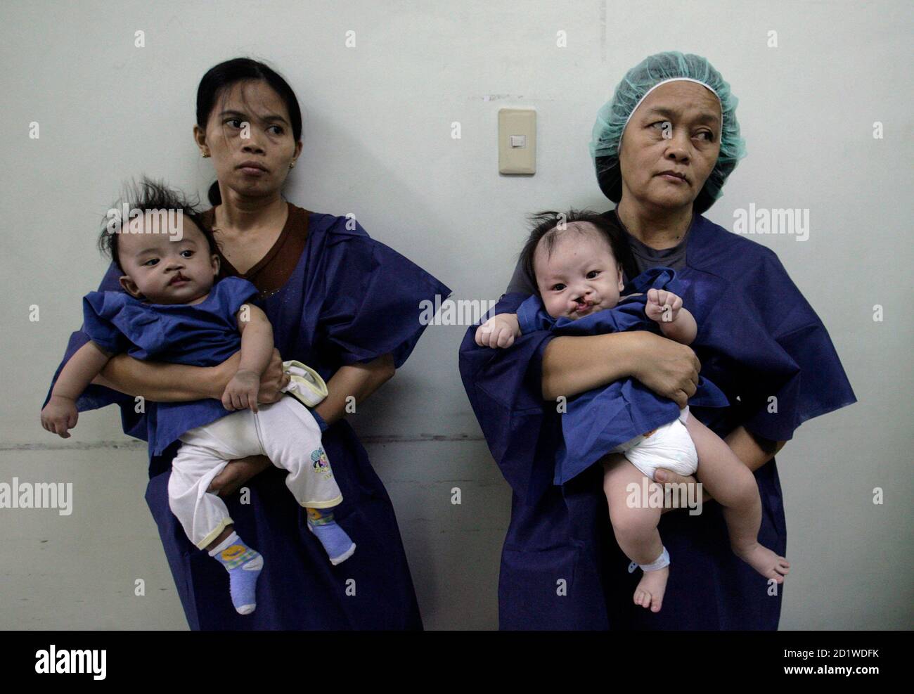 Baby boys, inflicted with cleft lips, are carried by their mothers as they wait for their surgery during 'Operation Restore Hope' at Diosdado Macapagal Memorial Medical Center in Caloocan City, Metro Manila April 12, 2010. Operation Restore Hope, a group of medical volunteers from Germany, New Zealand and Australia who perform surgeries for underprivileged children every year, aim to provide free surgery for about 70-80 children inflicted with cleft lips, cleft palates, and other facial deformities over a period of five days. REUTERS/Cheryl Ravelo (PHILIPPINES - Tags: HEALTH SOCIETY) Stock Photo
