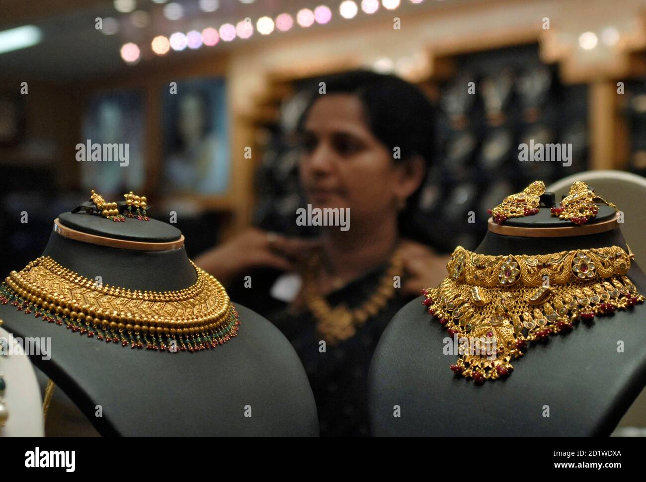 A woman tries on a gold necklace inside a jewellery shop in the southern  Indian city of Hyderabad May 14, 2010. India gold traders turned their  backs on the market on Friday