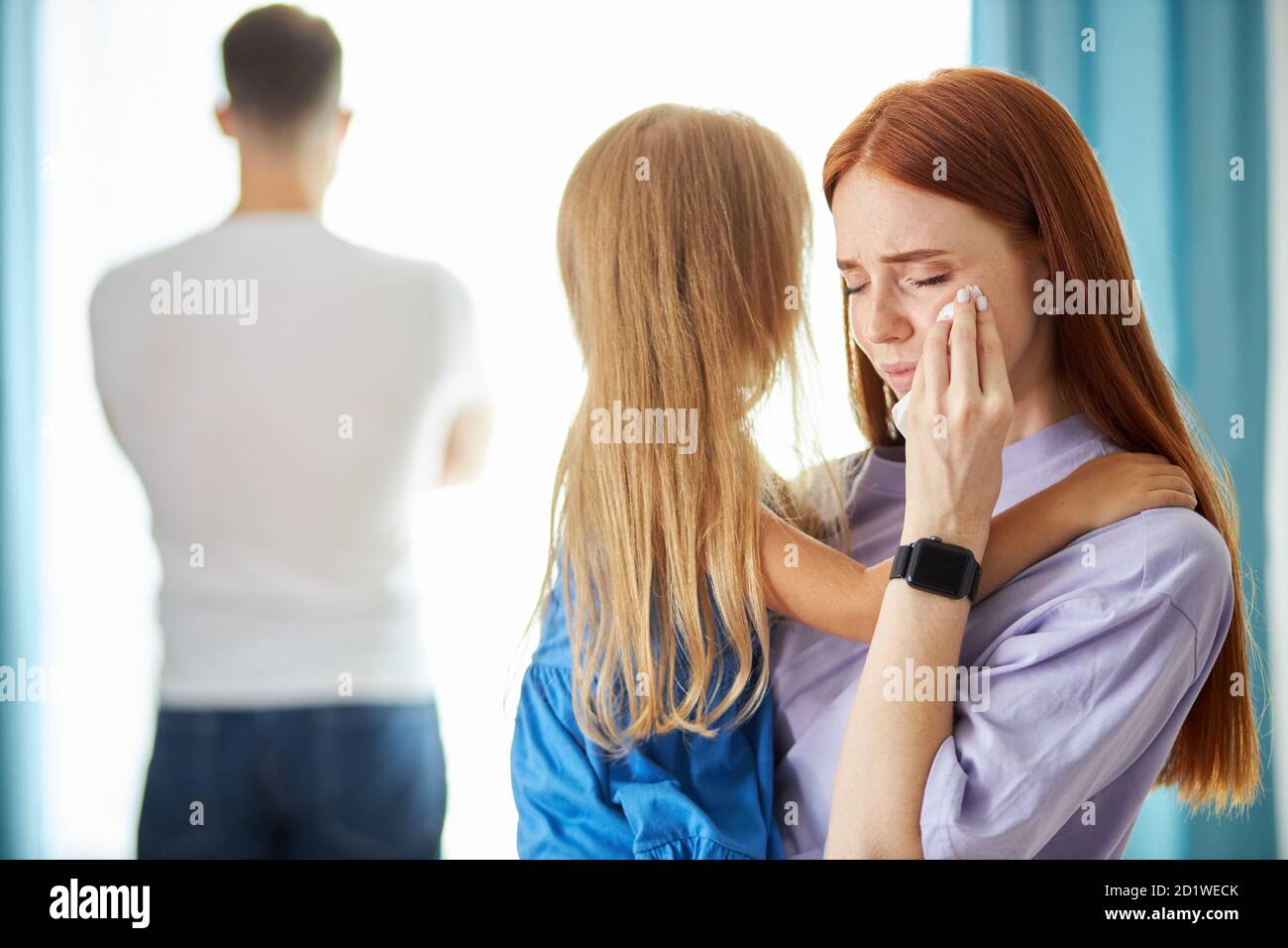 redhead caucasian woman with child girl leave man, he turned away from his family, cheated on his wife, he has a mistress Stock Photo