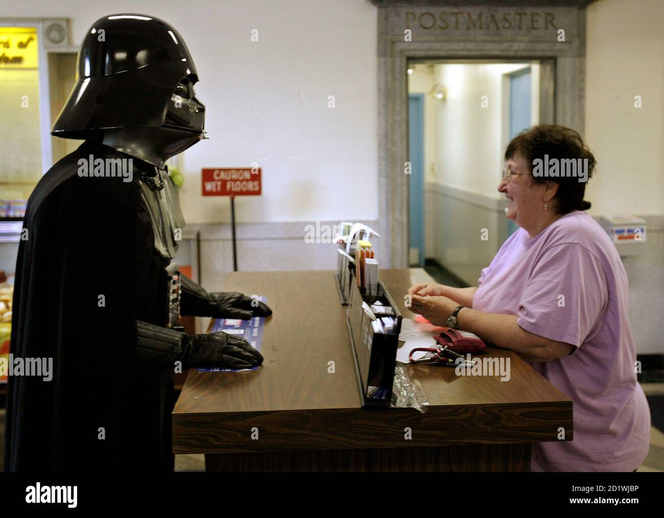 Jeff Gambell (L), dressed as Darth Vader from the Star Wars movies, talks  to Ellen Smith at the . Post Office in Norwood, Massachusetts May 25,  2007. The . Postal Service released