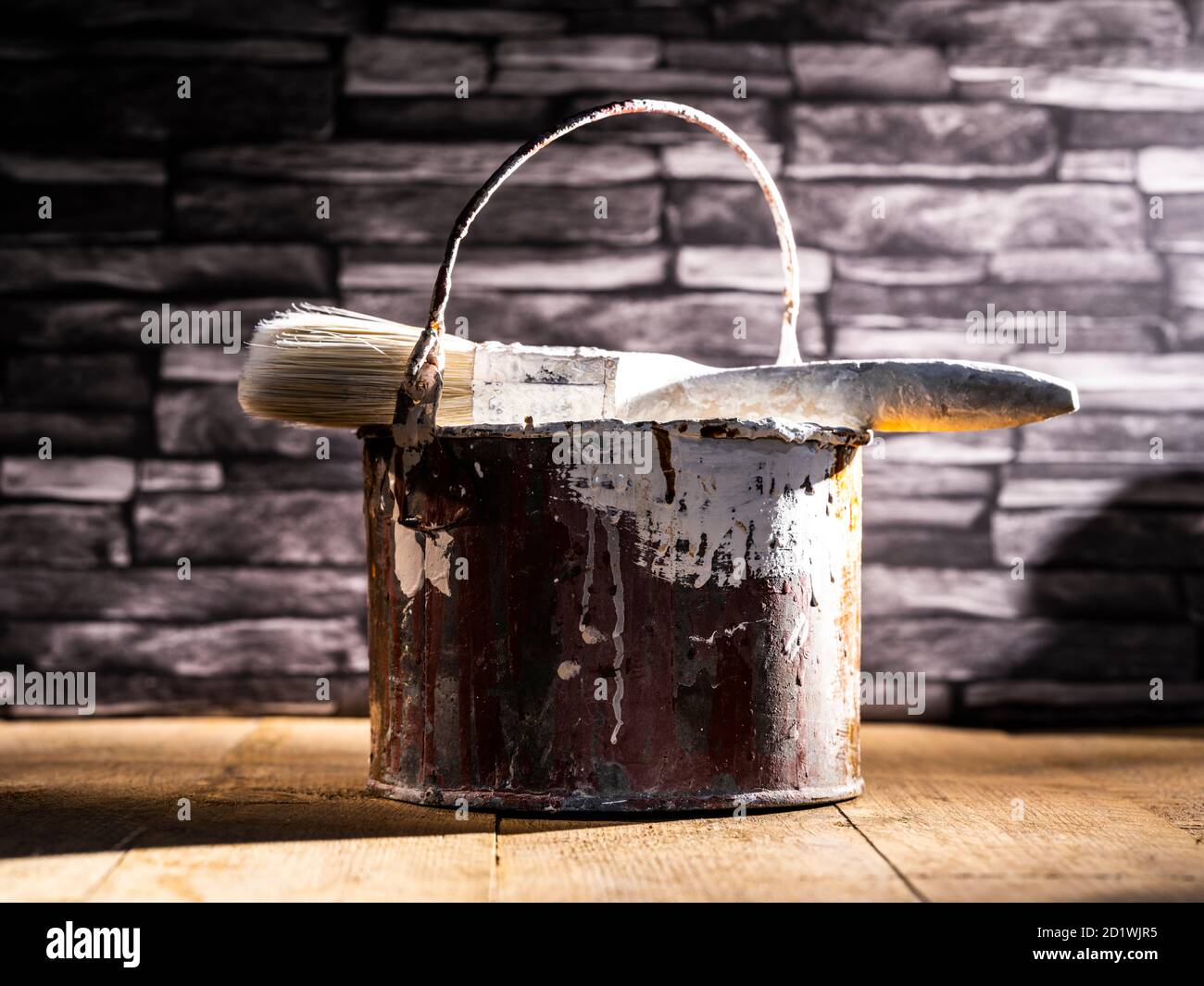 Paint tin bucket splattered with red and white paint with old paint