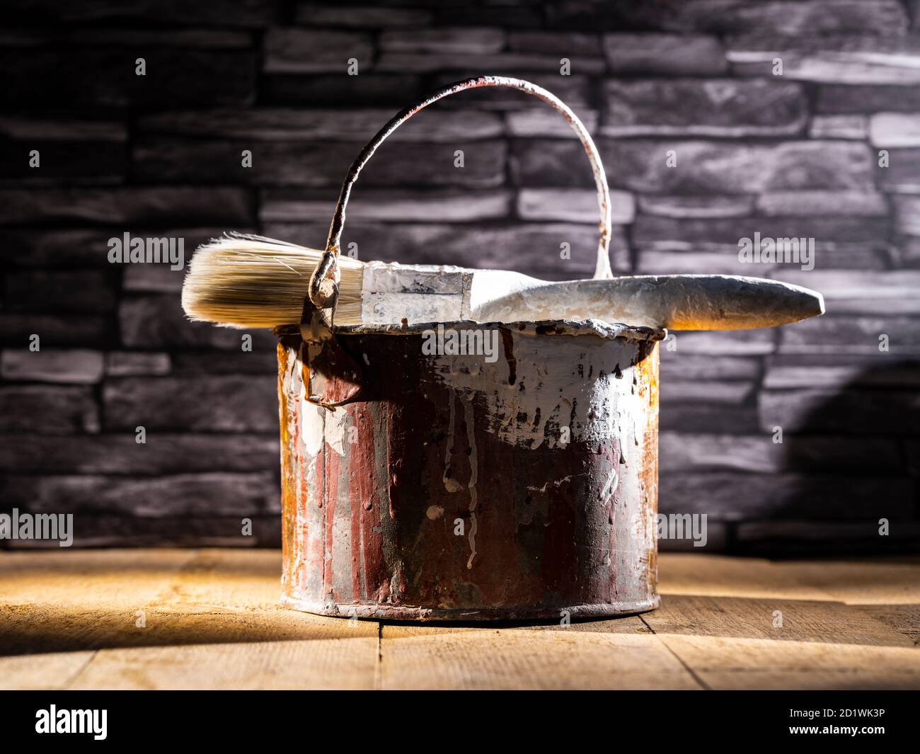 Paint tin bucket splattered with red and white paint with old paint
