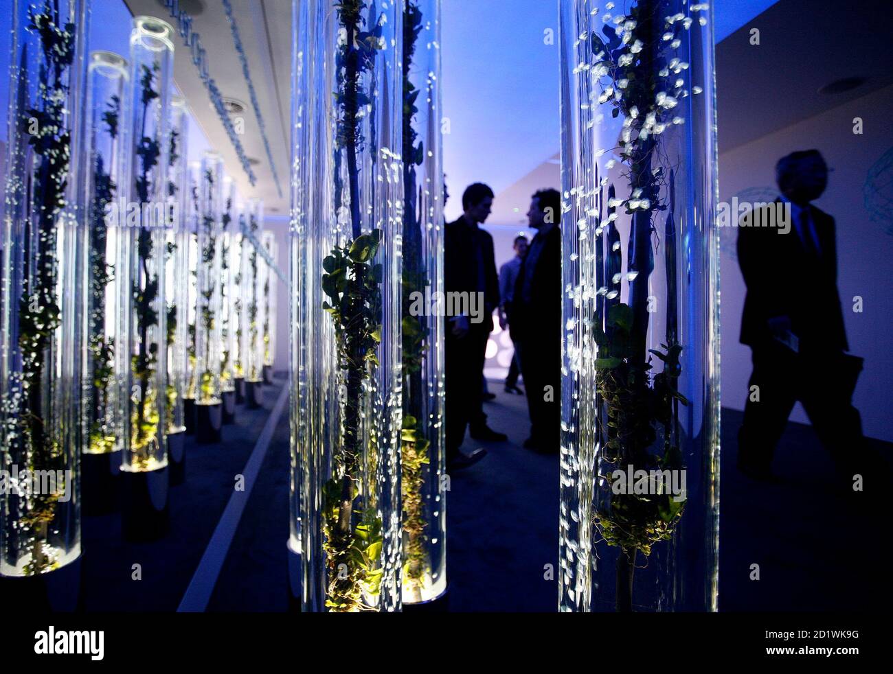 Visitors walk past a wall of water-filled tubes displayed at an information stand about Hybrid Synergy drive at the Frankfurt International Auto Show IAA in Frankfurt September 12, 2007. After two days for the media and analysts the Frankfurt motorshow will be open to the public from September 13 to 23. Green technology and lower fuel consumption will be a big theme at the largest and most prestigious auto show in the world this year.  REUTERS/Christian Charisius (GERMANY) Stock Photo