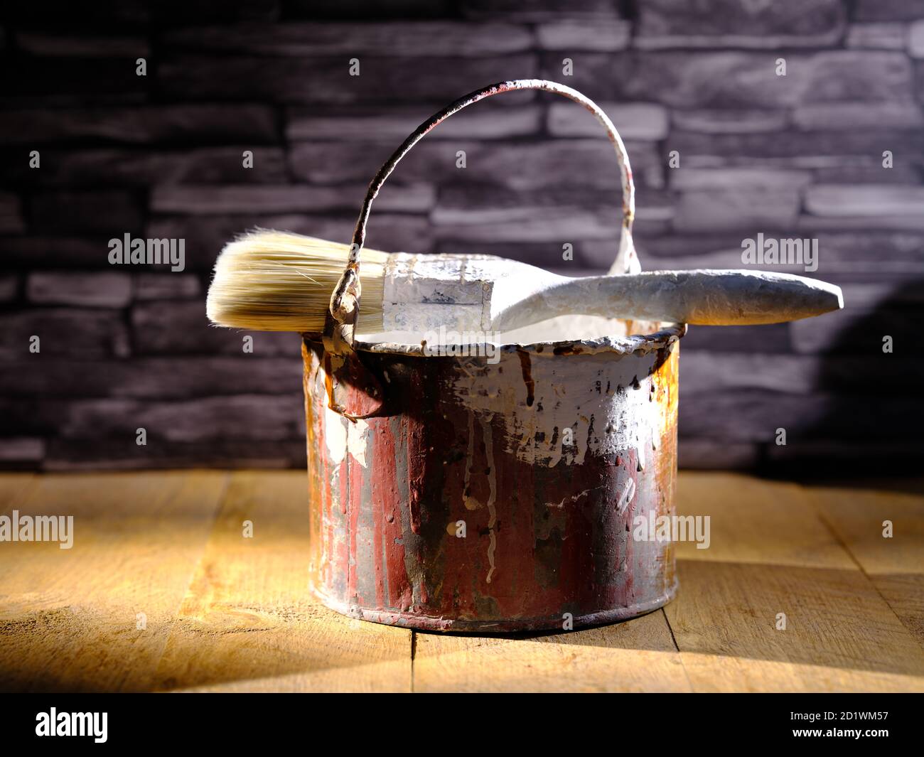 Paint tin bucket splattered with red and white paint with old paint