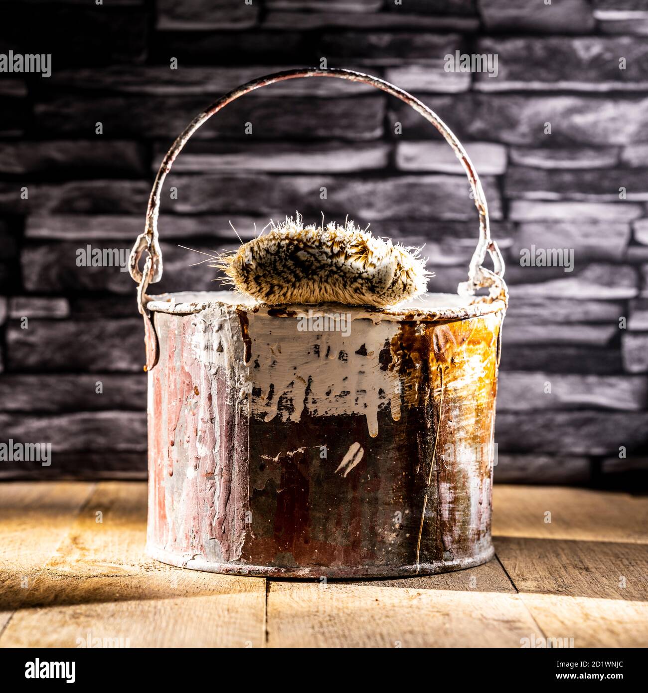 Paint tin bucket splattered with red and white paint with old paint