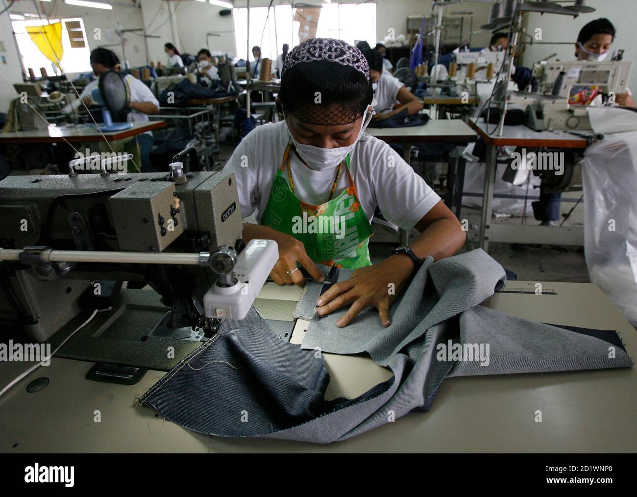 Workers make denim jeans for export at a garment factory in Manila June 17,  2008. The Philippine government passed a law on Tuesday exempting minimum  wage earners, including some factory workers, from