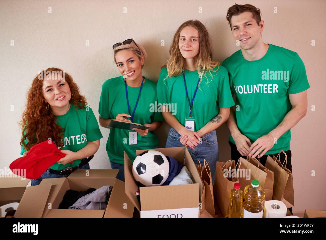 young enthusiastic volunteers with donations for poor people, cardboard