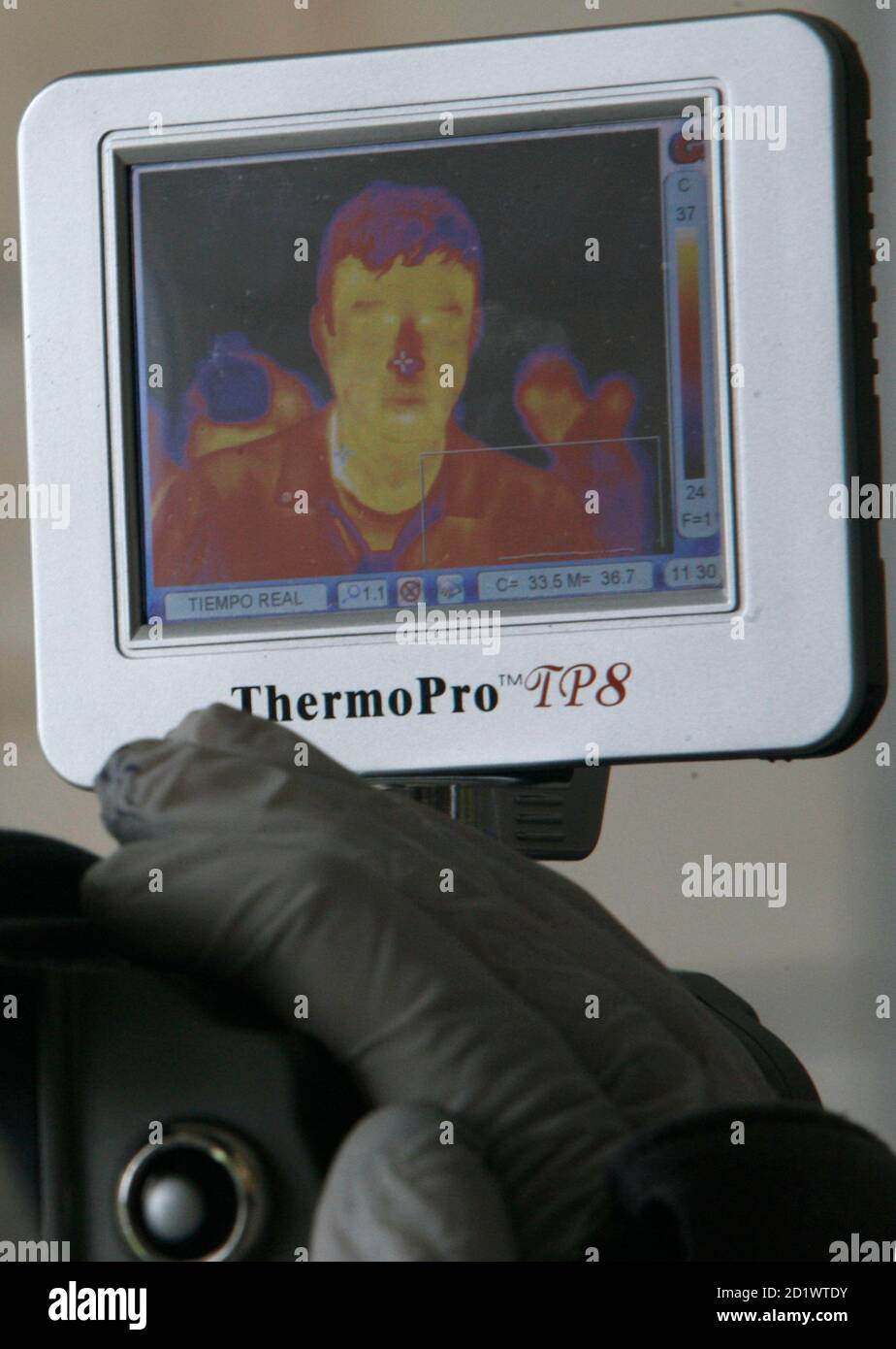 Passengers are seen through a thermal camera used to detect possible alterations in their body temperatures as they are scanned for influenza A (H1N1), formerly referred to as swine flu, upon their arrival at Toncontin airport in Tegucigalpa, April 30, 2009. The World Health Organisation (WHO), bowing to pressure from meat industry producers and concerned governments, said on Thursday it would refer to a deadly new virus strain as influenza A (H1N1), not swine flu. REUTERS/Edgard Garrido (HONDURAS) Stock Photo