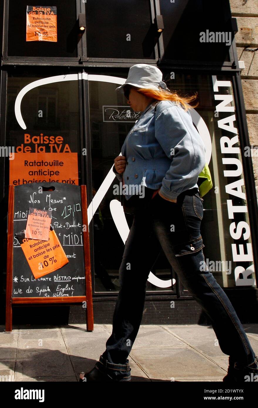 A woman walks past the restaurant 'Ratatouille' in Paris, June 23, 2009. The French parliament voted a bill that will reduce VAT in restaurants from 19.6% to 5.5% from July 1st, 2009.  The sign reads 'VAT reduction anticipated'.  Picture taken June 23, 2009. REUTERS/Benoit Tessier (FRANCE POLITICS BUSINESS FOOD) Stock Photo