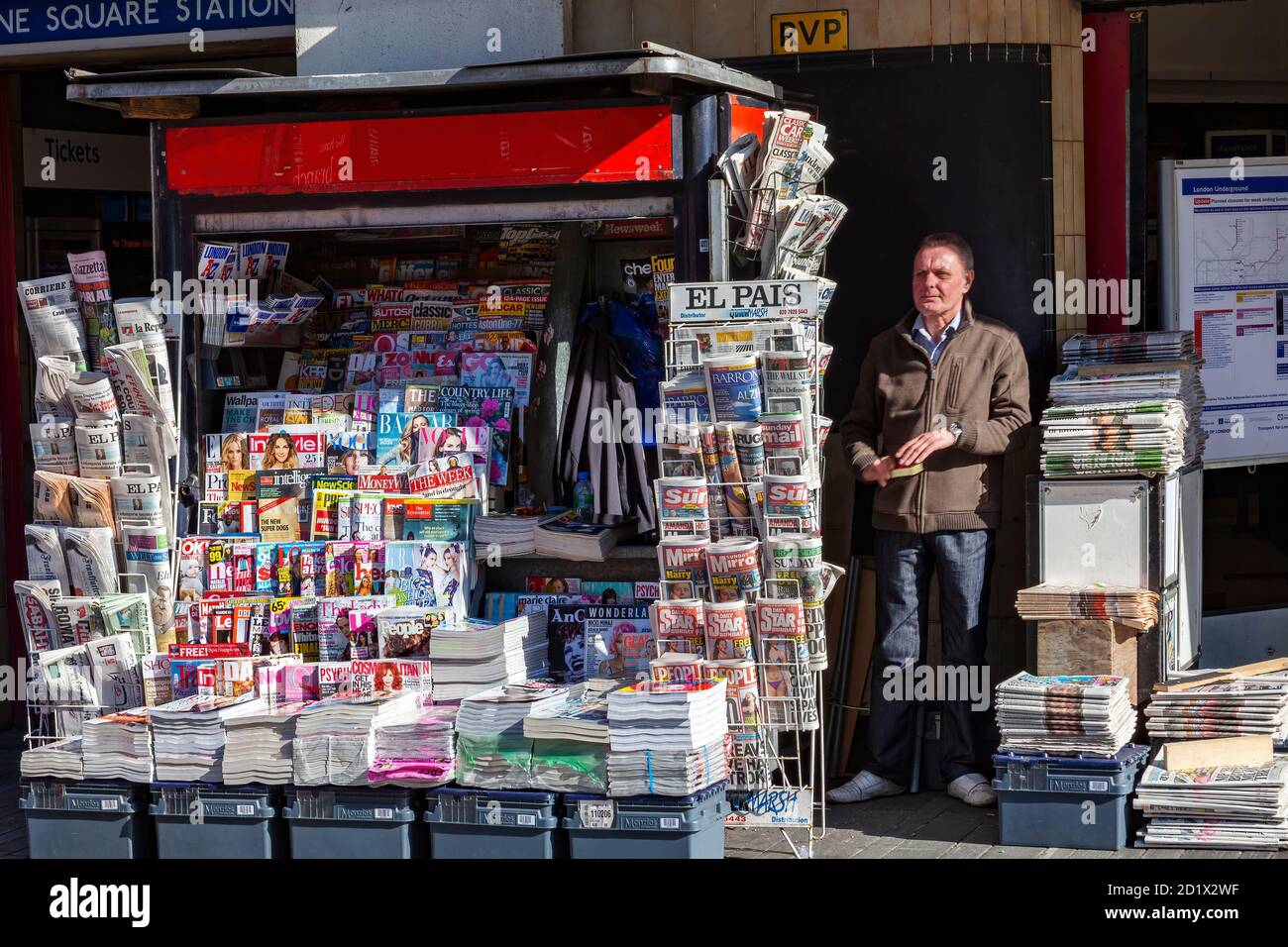 London, UK, February 26, 2012 : Vendor selling English and foreign newspapers and magazines at a newsagent stand outside Sloane Square tube station to Stock Photo