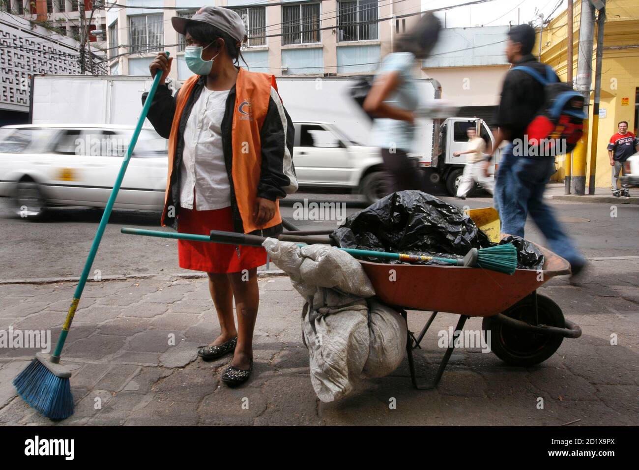 A municipal worker wears a mask to protect herself against the influenza A (H1N1), formerly referred to as swine flu, at downtown Tegucigalpa, April 30, 2009. The World Health Organisation (WHO), bowing to pressure from meat industry producers and concerned governments, said on Thursday it would refer to a deadly new virus strain as influenza A (H1N1), not swine flu.    REUTERS/Edgard Garrido  (HONDURAS HEALTH SOCIETY) Stock Photo