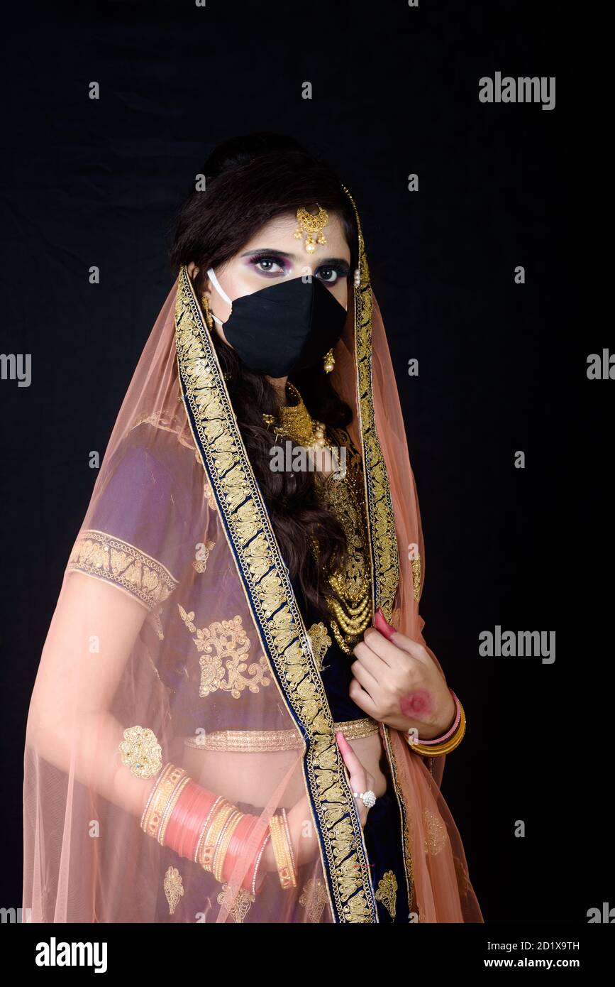 Bride wearing white Indian traditional cloth with face mask during wedding celebration in India Stock Photo
