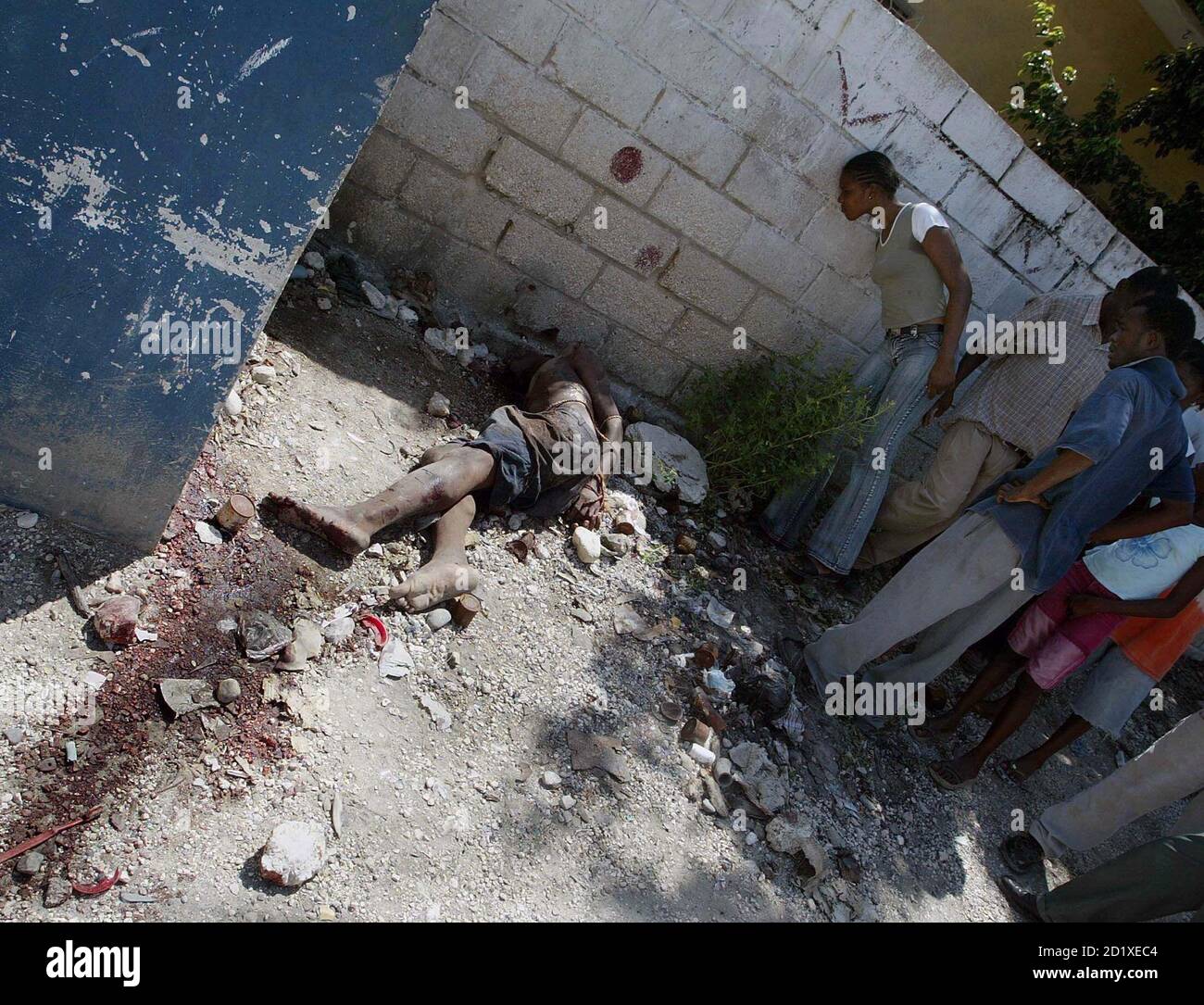 Haitians look at at a body, which has its hands tied up, in the Bel-Air neighborhood of Port-Au-Prince, Haiti September 20, 2005. Two men were stoned and hacked to death in the volatile neighborhood on Tuesday. A resident who said he witnessed the killings, said the victims belonged to armed gangs and were attacked by the neighborhood's residents. REUTERS/Eduardo Munoz Stock Photo