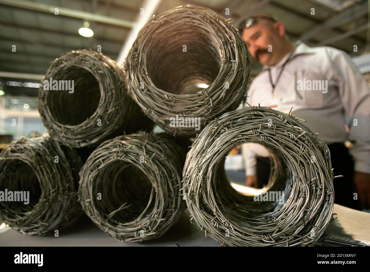 A man looks at rolled up barbed wires during the 5th International Trade  Fair for the Rebuilding of Iraq in Amman April 14, 2008. REUTERS/Muhammad  Hamed (JORDAN Stock Photo - Alamy
