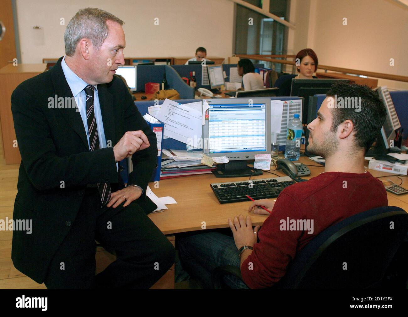 Britain's Work and Pensions Secretary John Hutton (L) meets an employee at i-level in London December 12, 2006. The government will unveil far-reaching pension proposals on Tuesday that could see workers enrolled automatically into schemes as part of a plan to plug the nation's estimated 57 billion pounds ($112 billion) savings gap. REUTERS/Kieran Doherty  (BRITAIN) Stock Photo