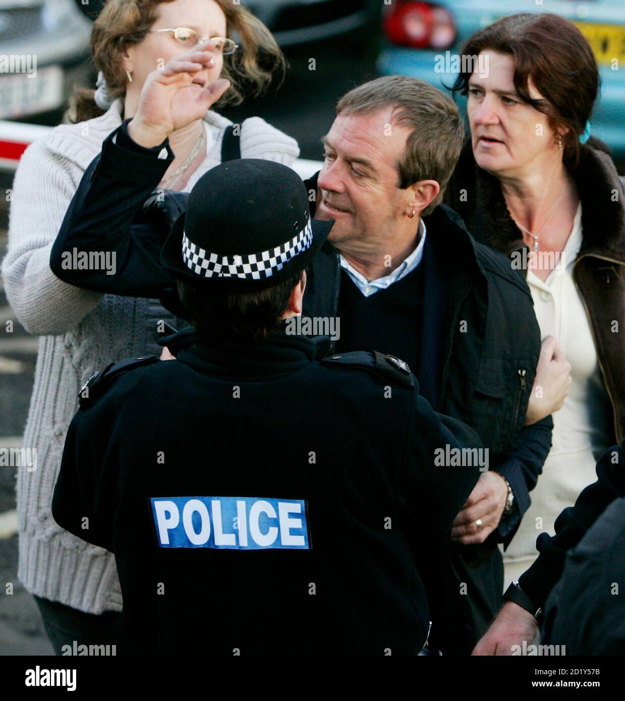 Michael Hamilton, the father of missing girl Vicky Hamilton, is restrained by family friends and a police officer as the prison van carrying Peter Tobin, who is accused of killing Vicky, leaves Linlithgow Sherriff Court, central Scotland November 15, 2007.  Tobin appeared in court on Thursday charged with murdering the teenage girl whose remains were found in a house in Kent, 16 years after she vanished from her home.      REUTERS/David Moir (BRITAIN) Stock Photo