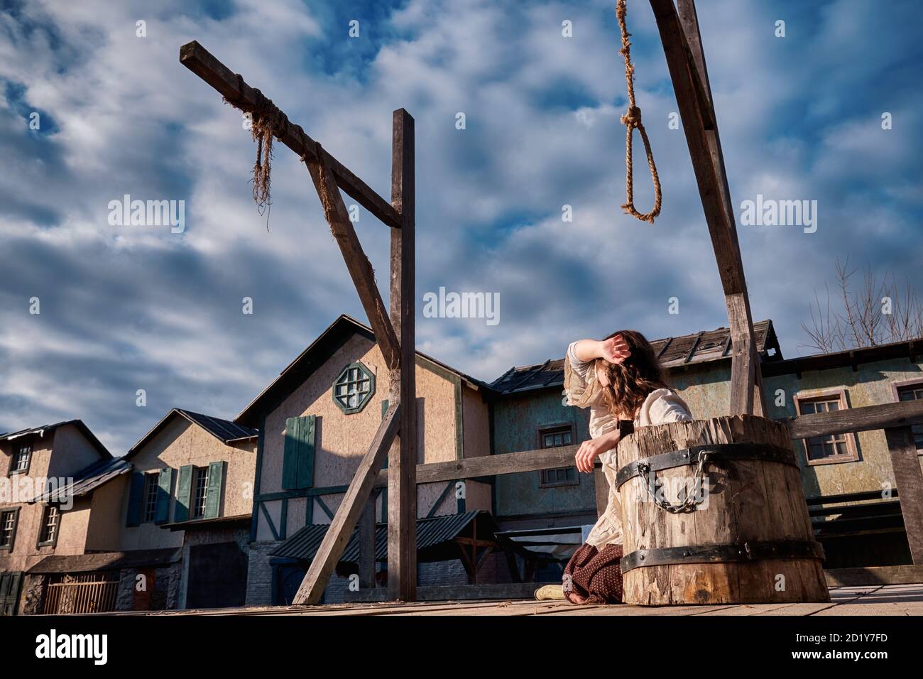A place to execute criminals by hanging in a vintage city of medieval Europe and a shackled woman Stock Photo