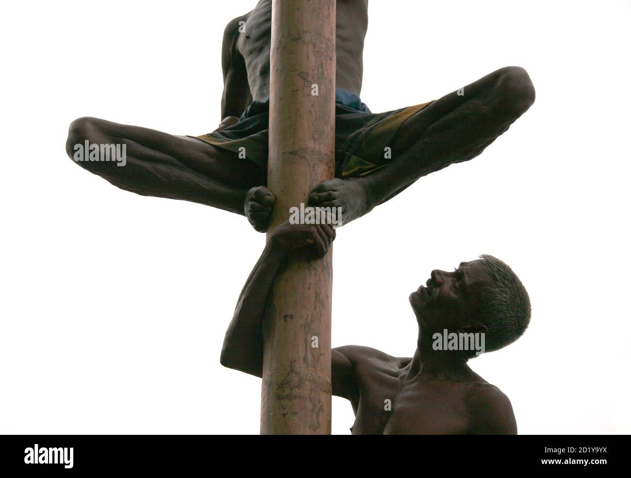 Sri Lankan men participate in a greasypole climbing competition that