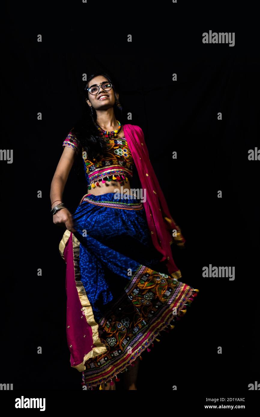 Foto Stock Indian girl in traditional chaniya choli for navratri with a  fashionable hairstyle poses in studio on black background Navratri is an  Indian Festival and Chaniya choli its traditional costume 