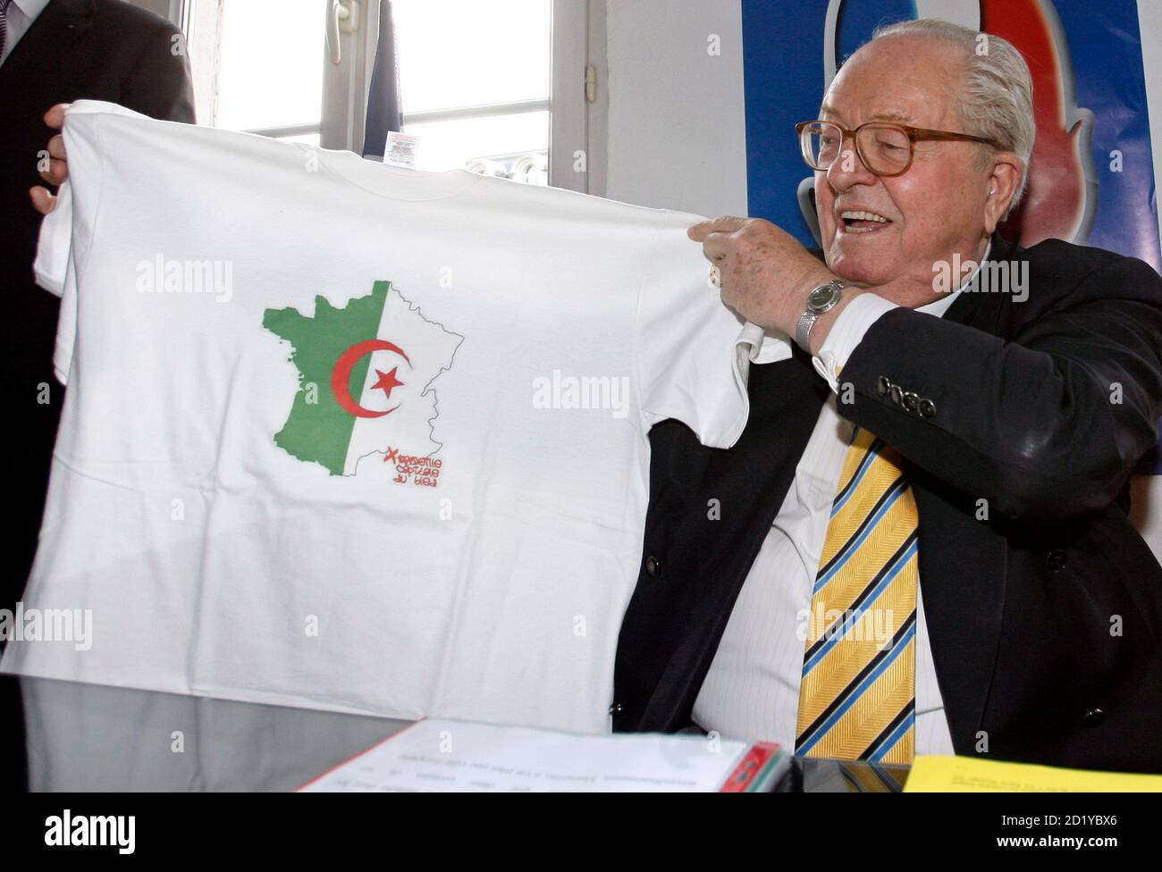 France's far-right National Front political party leader Jean-Marie Le Pen  holds a t-shirt with the Algerian flag on a map of France during a news  conference at the new National Front party