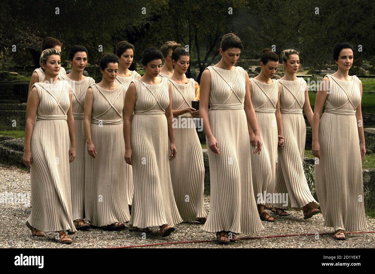 A group of white-robed priestesses carry the Olympic flame in a replica of  an ancient Greek pot during a ceremony in front of the Temple of Hera in  ancient Olympia November 27,