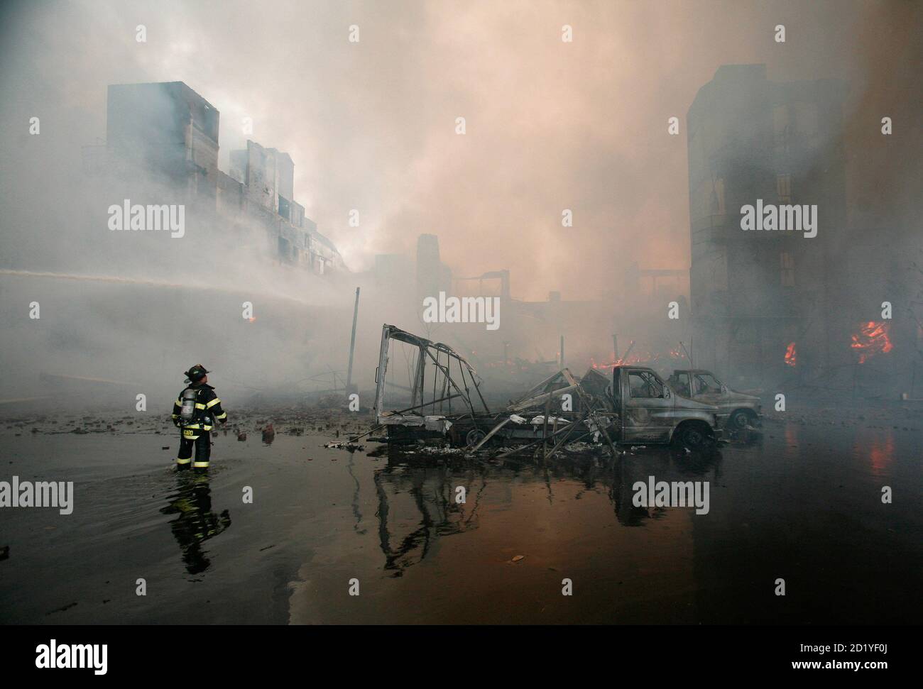 A New York City fireman battles a fire at a waterfront warehouse in Brooklyn, New York, May 2, 2006. The blaze, which had reached eight-alarm status and engulfed several buildings and wharfs along the East River, could be seen for miles.  Fire Commissioner Nicholas Scoppetta called it the largest fire in the city in more than a decade, excluding the World Trade Center attack. Stock Photo