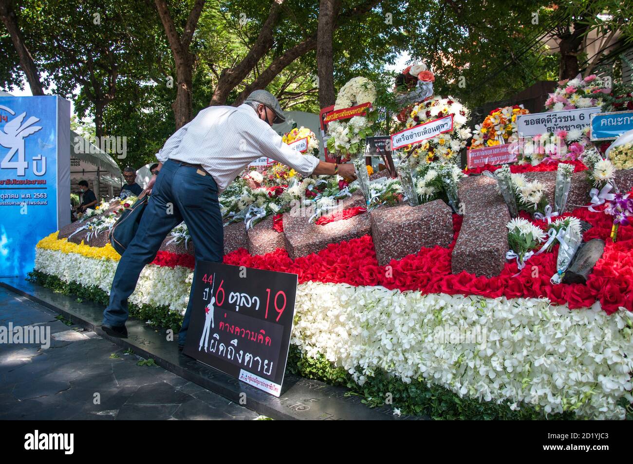 A man lays flowers in the memorial for the victims of the Thammasat University Massacre.The 6 October 1976 Thammasat University massacre was a violent crackdown by Thai police joined with right-wing paramilitaries against leftist protesters and students who had occupied Bangkok's Thammasat University. Stock Photo