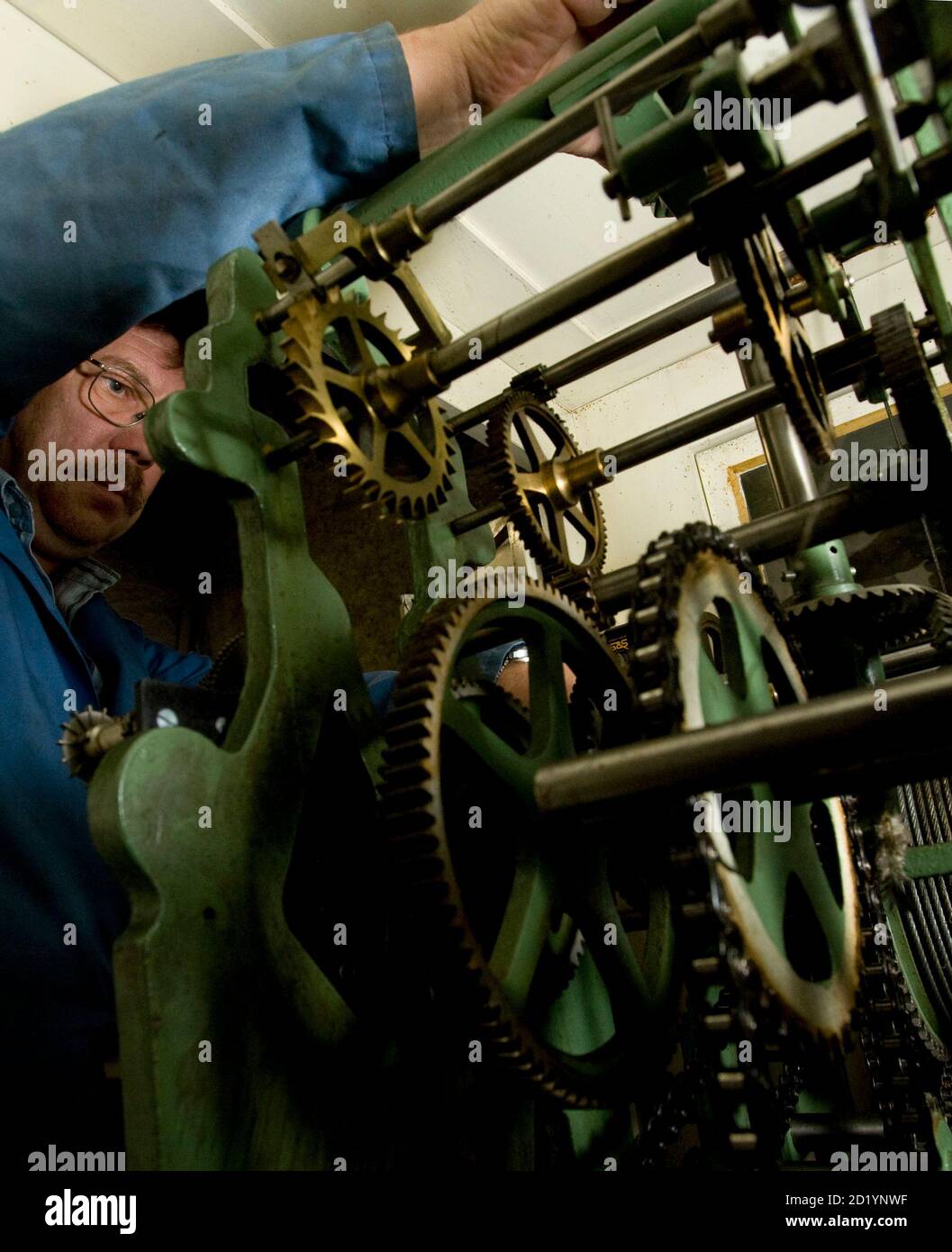 City of Geneva watchmaker Pierre-Andre Luethi winds the clock back at the  church in Le Petit Saconnex in Geneva October 25, 2008. Luethi will  manually wind back more than 30 clocks in