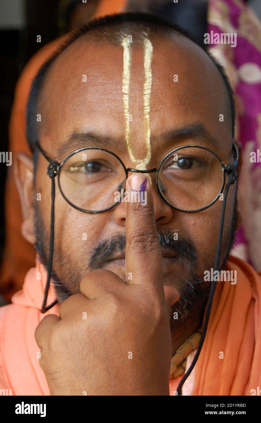 A Sadhu or a Hindu holyman shows his ink-marked finger after casting his ballot outside a polling station in the northern Indian city of Mathura May 7, 2009. Millions of Indians began voting in the fourth round of a general election on Thursday, including the possible swing state of West Bengal where the ruling Congress-led alliance hopes to win crucial seats. REUTERS/K.K. Arora (INDIA POLITICS ELECTIONS) Stock Photo