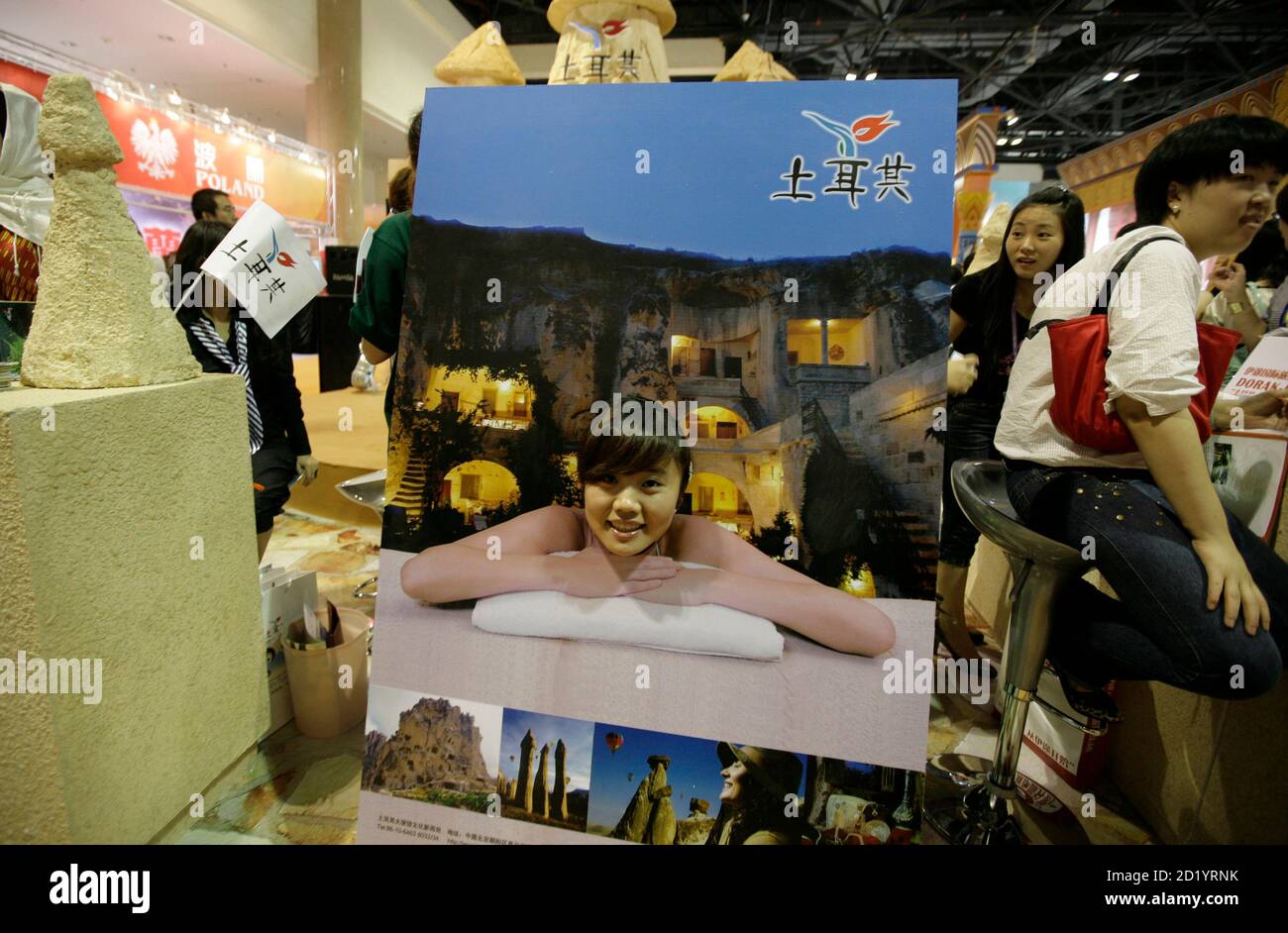 A woman poses in a hole cut in a poster at the Turkish booth at an international tourism exhibition in Beijing, June 18, 2009. REUTERS/Jason Lee (CHINA TRAVEL SOCIETY BUSINESS) Stock Photo