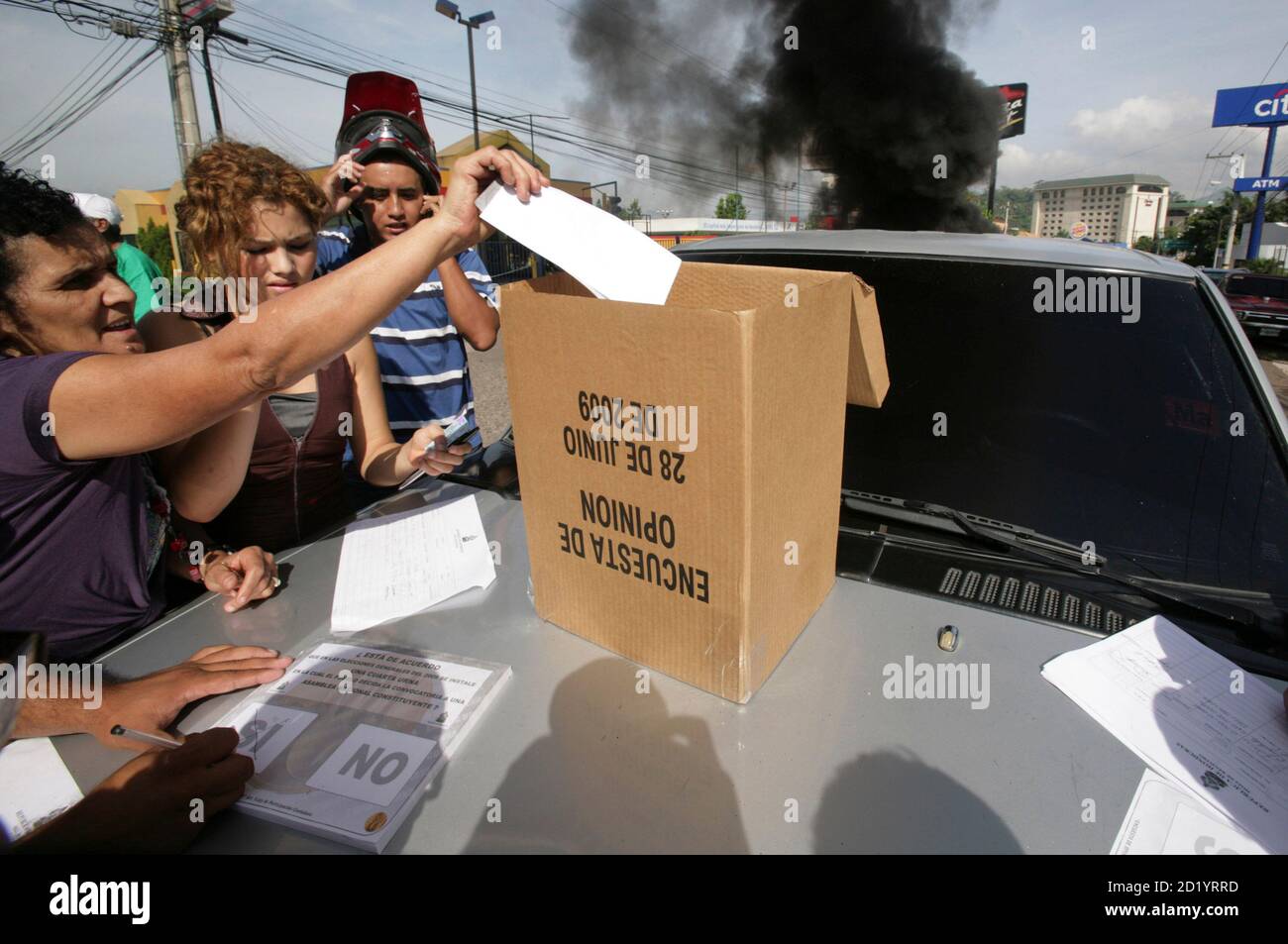 A woman casts a symbolic vote as a show of support for Honduras' President Manuel Zelaya on the streets near the presidential residency in Tegucigalpa June 28, 2009. Witnesses said Zelaya was detained at home by troops in a constitutional crisis over his attempt to win re-election. CNN's Spanish-language channel later quoted Costa Rican officials as saying he was in Costa Rica and seeking political asylum. An unofficial referendum on allowing presidents to serve more than a single four-year term was originally supposed to take place on Sunday. REUTERS/Oswaldo Rivas (HONDURAS POLITICS CONFLICT Stock Photo