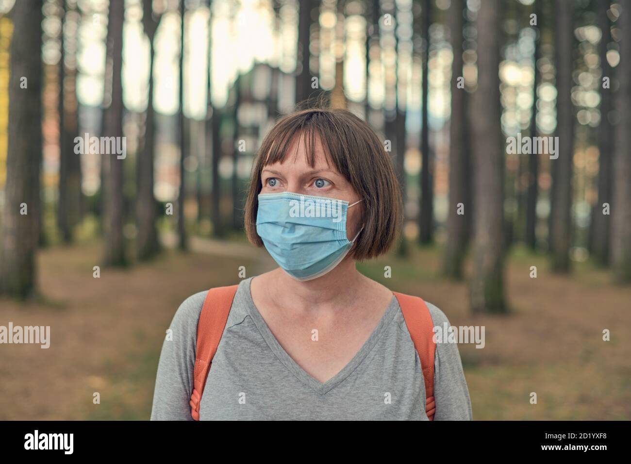 Casual woman in everyday protective face mask concept posing in park