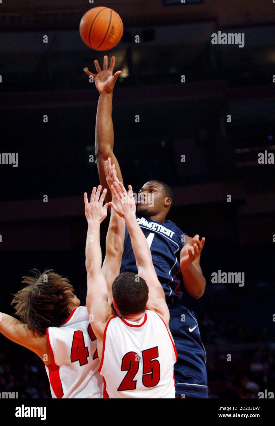University of Connecticut's Jeff Adrien shoots over the defense of Gardner-Webb University's Auryn MacMillan (L) and Nate Blank (R) during the second half of their semi-finals game at the Coaches vs Cancer Classic NCAA college basketball tounament in New York, November 15, 2007. REUTERS/Mike Segar (UNITED STATES) Stock Photo
