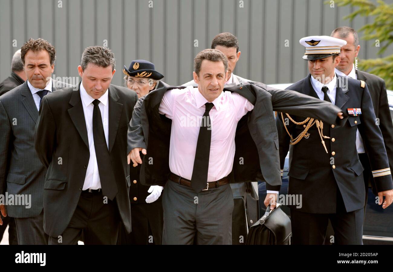 France's President Nicolas Sarkozy (C) puts on his jacket as he arrives at  the Ester Limoges Technopole in Limoges, central France, to deliver a  speech on competitiveness, June 26, 2008. Cerlase is