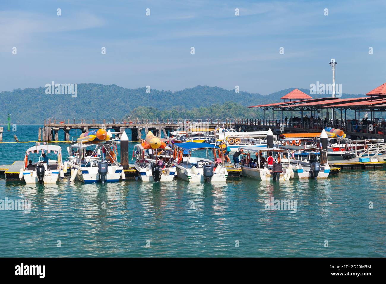 Kota Kinabalu, Malaysia - March 17, 2019: Small motorboats with passengers are moored near Jesselton Point ferry terminal at sunny day Stock Photo