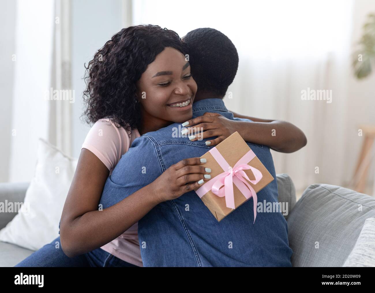 Happy african lady with present hugging her lover Stock Photo - Alamy