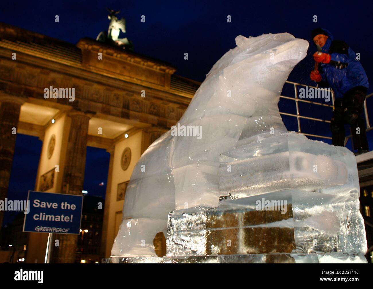 German ice sculpture artist Christian Funk, carves a polar bear out of 15 tons of ice near the Brandenburg Gate in Berlin, December 7, 2007. According to Greenpeace, the ice sculpture is a memorial for climate protection. The sculpture is four meters high, four meters long and 1,5 meters wide. REUTERS/Johannes Eisele (GERMANY) Stock Photo