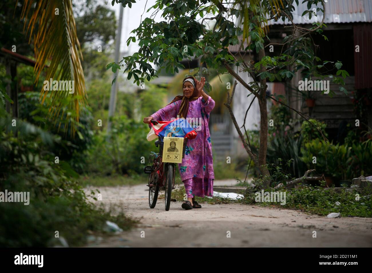 Malaysia S Independent Candidate For Kuala Terengganu S Parliamentary Seat Maimun Yusuf Waves As She Campaigns In The Northeast Malaysian State Of Terengganu March 3 2008 The 89 Year Old Grandmother Using Her Rusty Bicycle Displayed